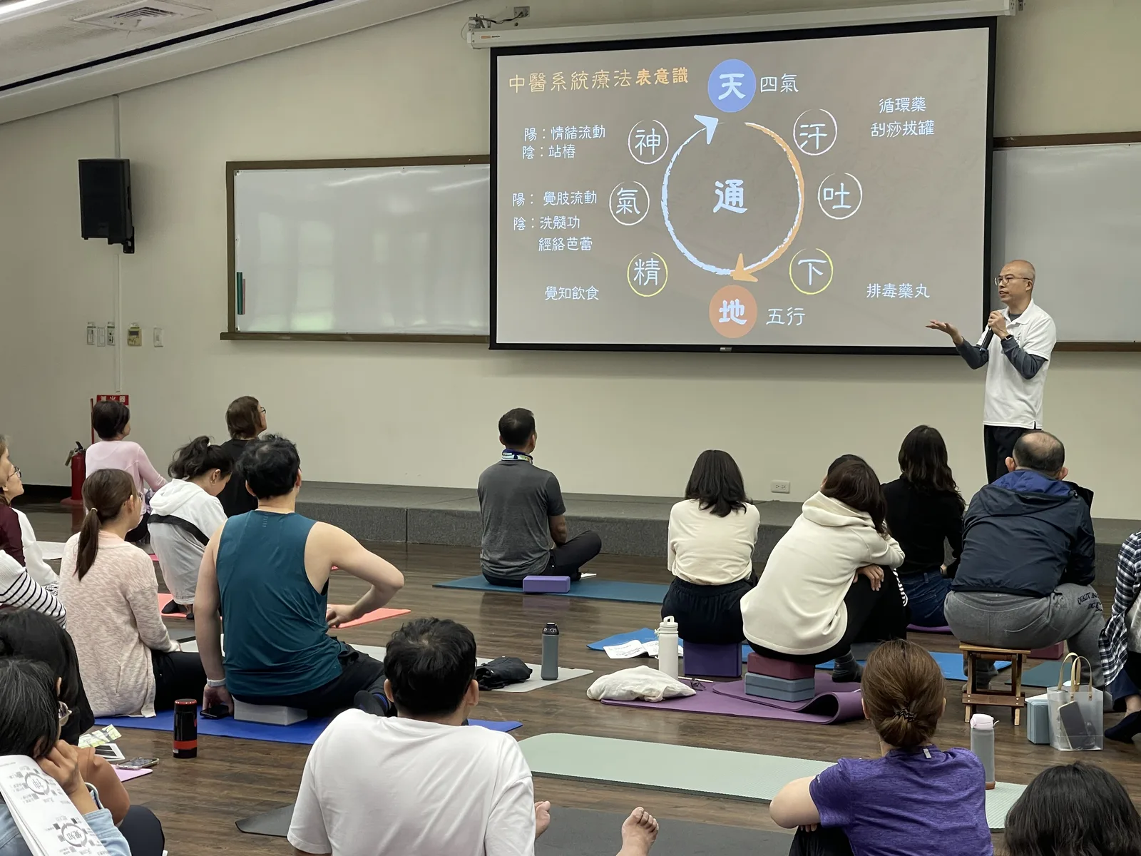 講師說明中醫系統觀念，學員席地聆聽