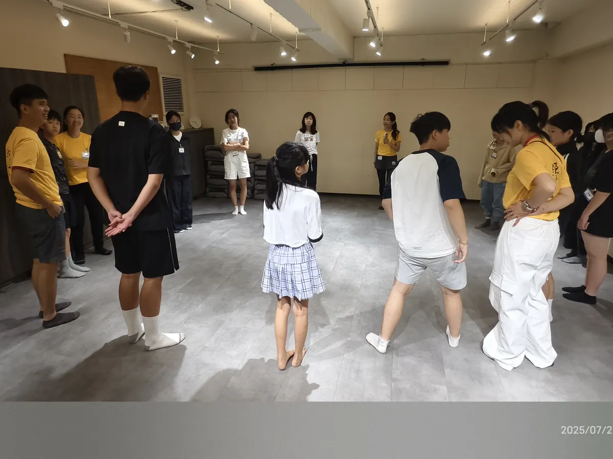 青少年與帶領者圍成一圈進行暖身活動