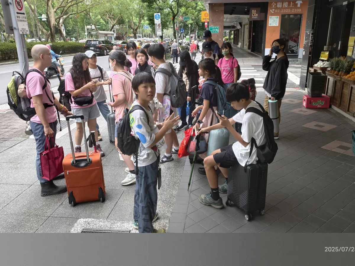 青少年帶著行李集合準備前往營地